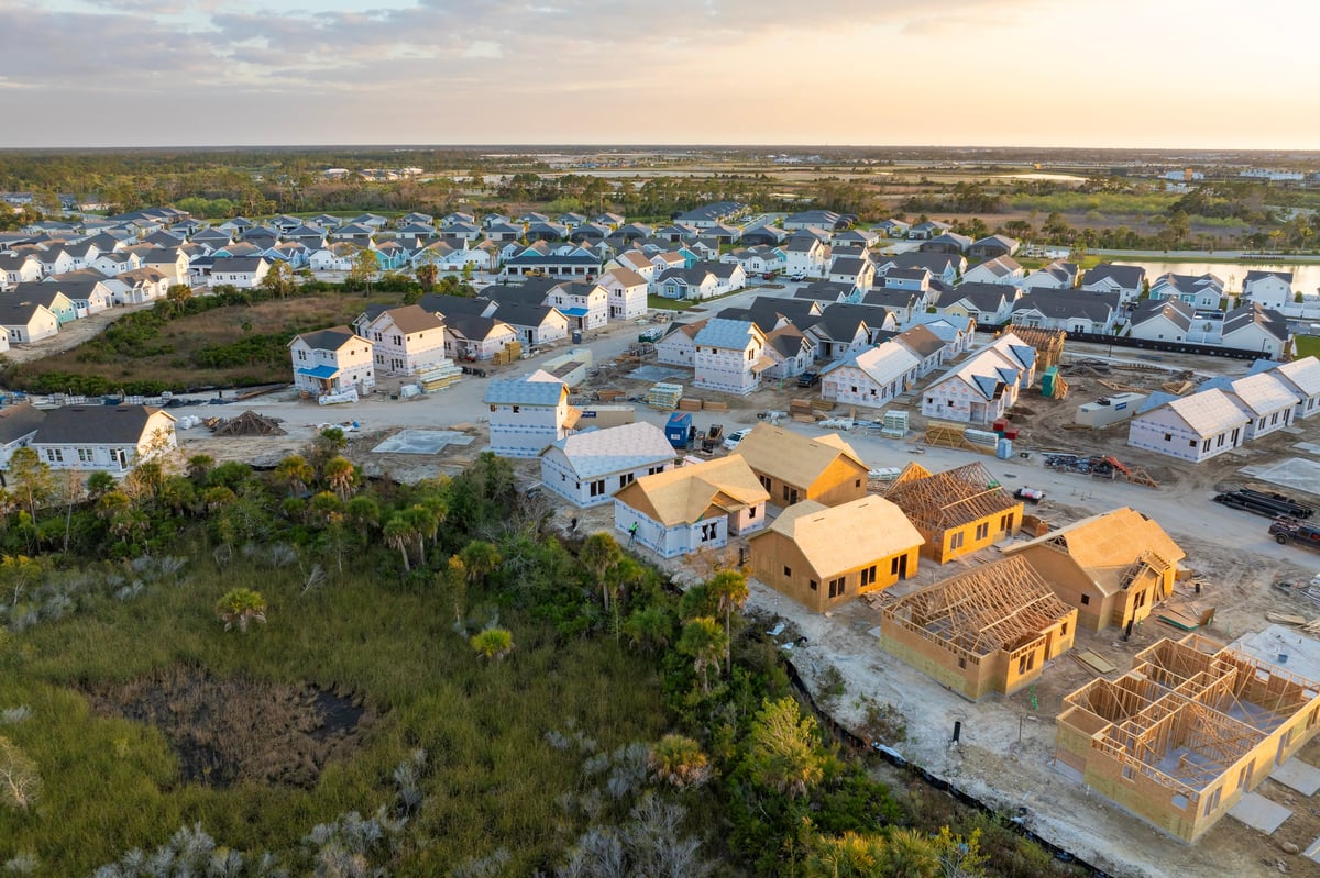 Wooden houses under construction in new developing suburban area. Development of residential housing in American suburbs.