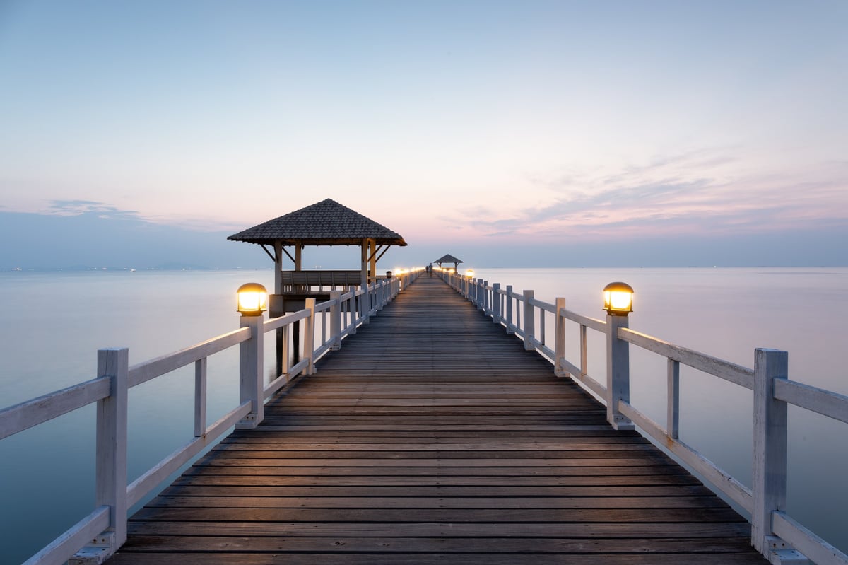 Beautiful pavilion and wooden bridge with empty sky and calm sea in background at travel attraction