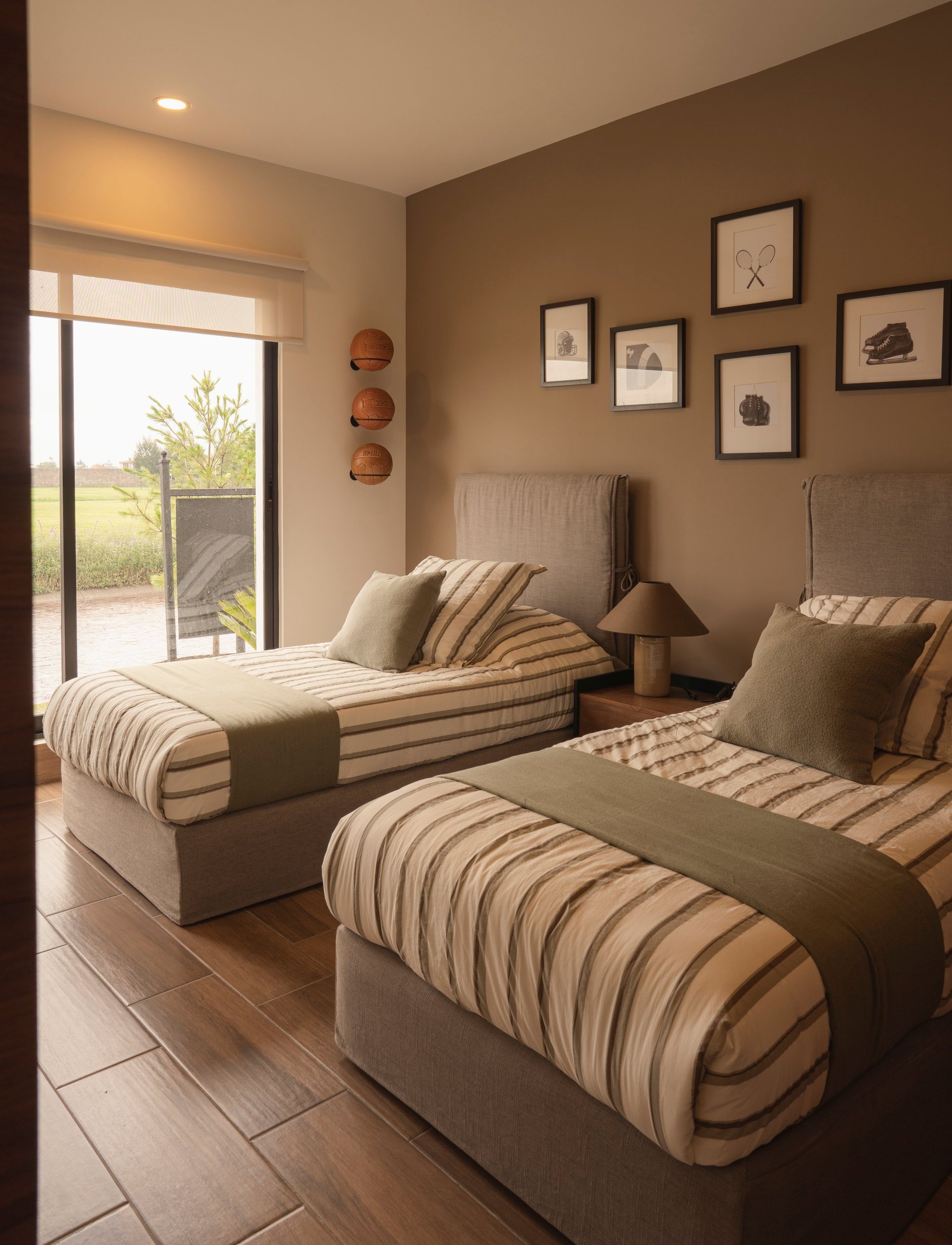 Modern bedroom with two twin beds with striped bedding, wall art, and glass door overlooking outdoor terrace