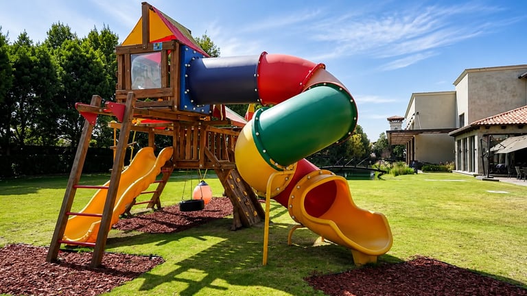 Colorful wooden playground structure with slides and climbing tower in sunny backyard setting