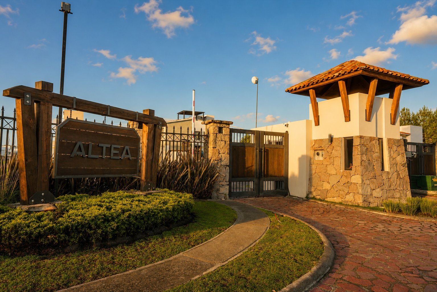 Entrance to Altea with wooden gate sign, tower structure, and landscaped grounds under blue sky